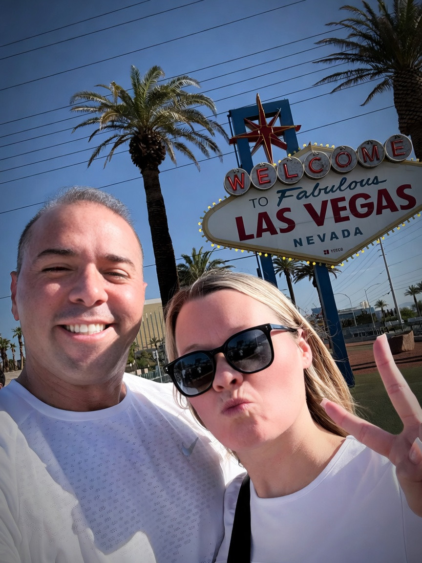 Jordan smiling and Danielle making a peace sign at the Las Vegas sign