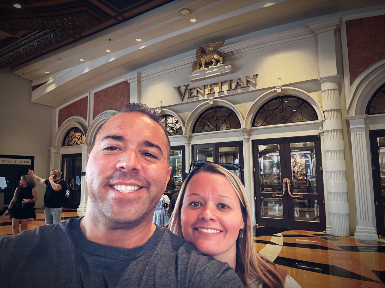Jordan and Danielle smiling beneath the Venetian entrance sign